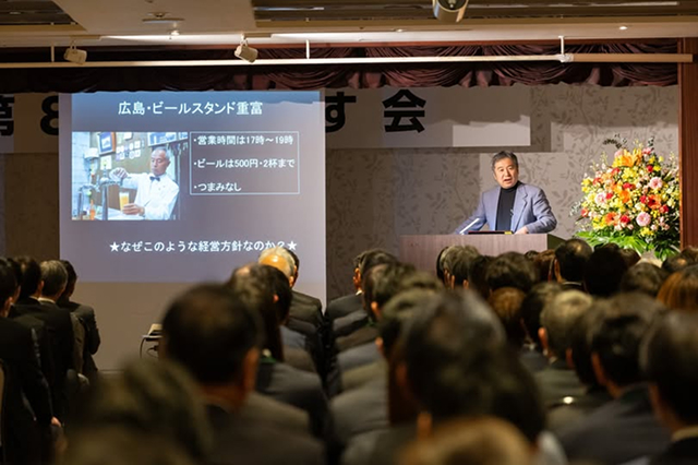 会場の参加者に向けて講演する田中靖浩